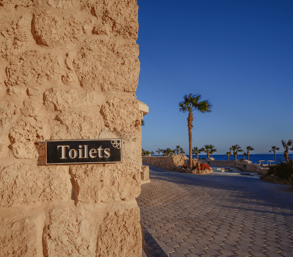 Toilet sign by a beautiful beach