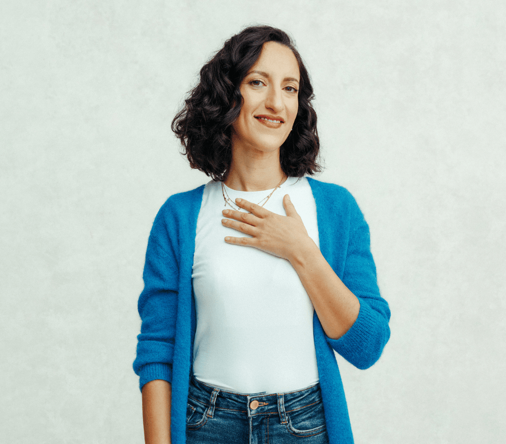 A woman holding her hand to chest