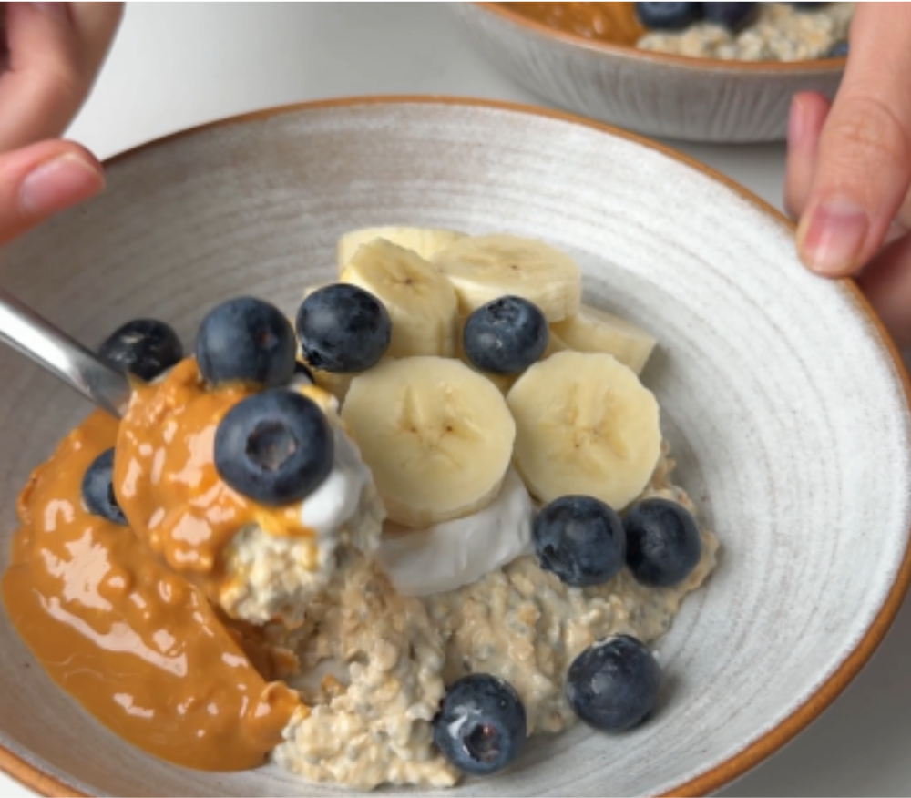 A bowl of speedy oats topped with nut butter, blueberries and banana